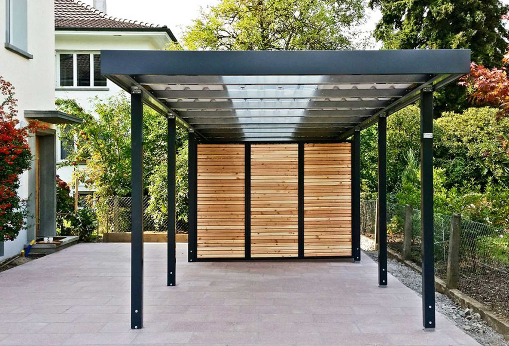 Carport mit Geräteraumeinbau und transparenter Dacheindeckung.